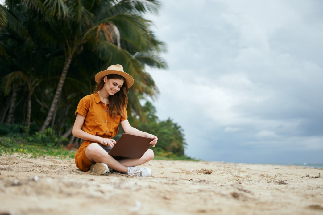 happy-traveler-working-sitting-on-the-island-with-a-laptop-on-her-lap_t20_ErOoP7