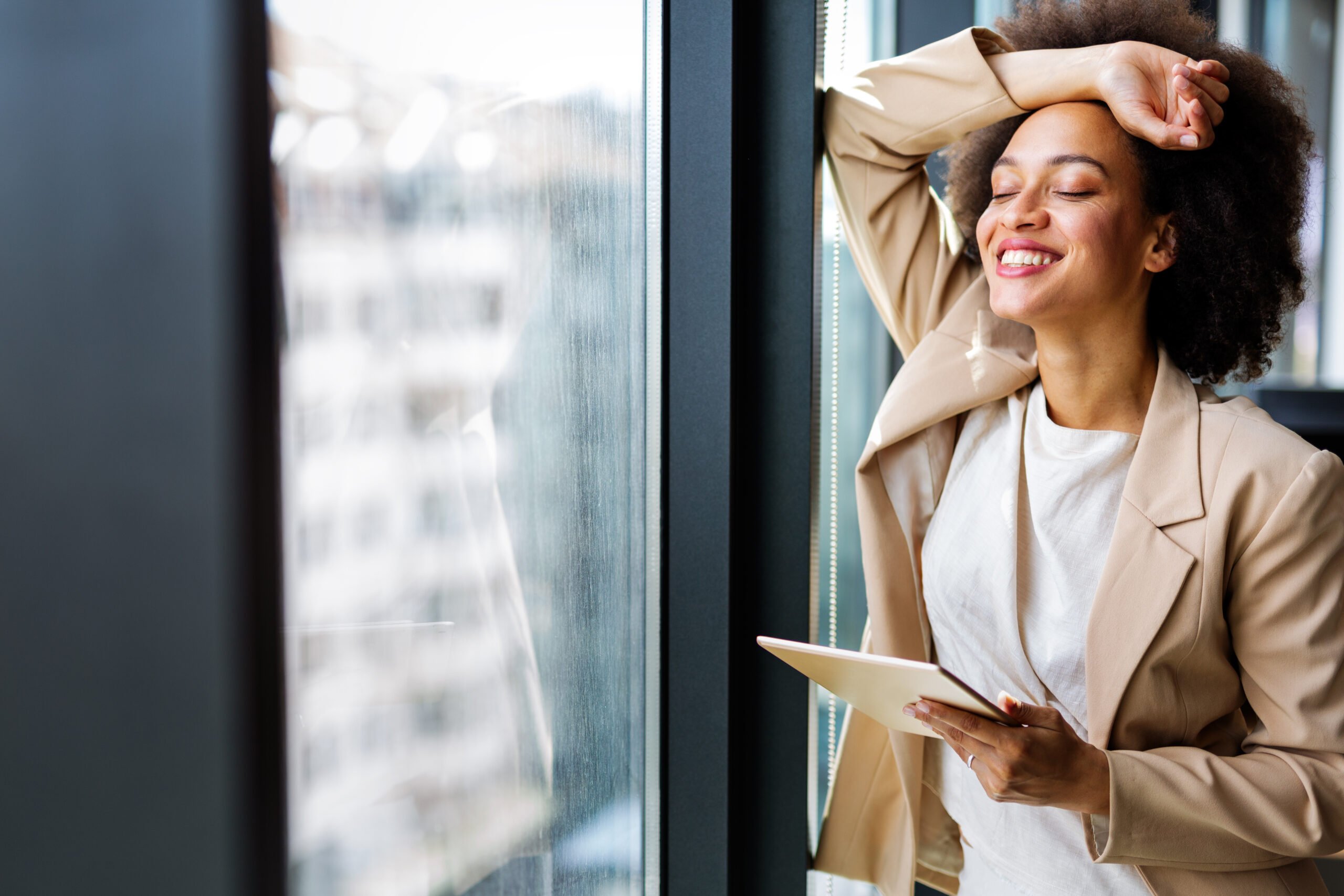 Portrait of a smiling confident african american young businesswoman working with digital tablet